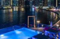 a swimming pool on a boat in the water at night at Canal Central Hotel Business Bay in Dubai