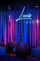 um palco com um violino e uma placa que diz "nosso" em Hotel Monarch em Batumi