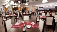 a restaurant with tables and chairs with red napkins at Clarion Congress Hotel Olomouc in Olomouc