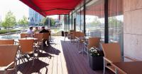 two people sitting at tables on a deck in a restaurant at Clarion Congress Hotel Olomouc in Olomouc