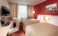 a hotel room with two beds and a desk with a laptop at Clarion Congress Hotel Olomouc in Olomouc