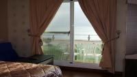 a bedroom with a view of the ocean from a window at Ibizakenting Hotel in Kenting