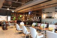 Un restaurante con mesas y sillas y un bar. en Palm Springs Hotel Dili, en Dili