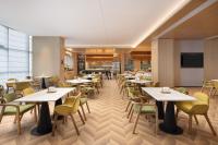 a restaurant with tables and chairs and a television at Home2 Suite by Hilton Chongqing Wanzhou in Wanzhou