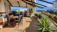 Un patio con mesa y sillas y plantas. en Hotel Pop, en Cala Gonone
