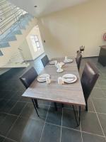 a wooden table with chairs and plates and dishes on it at Chill Out in Malelane