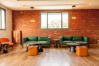 a waiting room with green seats and a brick wall at Casa Hotel, Jubilee Hills in Hyderabad