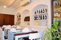 B&b la bottega في تريبيساتشيه: مطعم بطاولات بيضاء وزجاجات من النبيذ