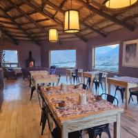 Un comedor con mesas y sillas y ventanas. en Cabañas Bodega Kindgard, en Purmamarca