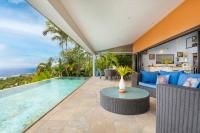 a swimming pool in a house with a couch and a table at Villa Ireina magnificent sea view in Punaauia