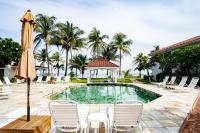 una piscina con sillas, una sombrilla y un cenador en Isla Bonita Yacht Club, en San Pedro
