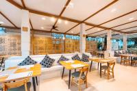 een restaurant met tafels, stoelen en een bank bij Khaolak Emerald Beach Resort and Spa in Khao Lak