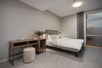 トロムソにあるEnter Skansen Hotelのベッドと机と窓のある寝室