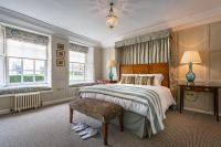 a bedroom with a bed and a chair and windows at The Assembly House in central Norwich in Norwich