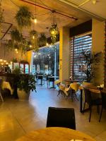 ein Restaurant mit Tischen und Stühlen sowie Pflanzen und Lichtern in der Unterkunft Maravilhoso Studio - Granja Brasil Itaipava in Itaipava