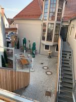 an outdoor patio with chairs and umbrellas in front of a house at Hotelgasthof Kirchenwirt in Schierling