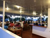 a group of people sitting at tables in a restaurant at Tongatok Cliff Resort in Mambajao