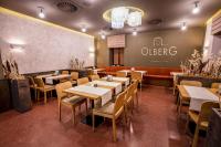 Un restaurante con mesas y sillas y un cartel en la pared. en Hotel Olberg, en Olomučany
