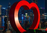 a large red heart in front of a window with a city at Canal Central Hotel Business Bay in Dubai