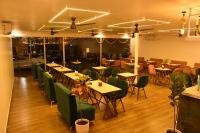 a dining room with tables and green chairs at Escape Goa in Palolem