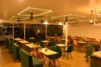 a dining room with tables and chairs and lights at Escape Goa in Palolem