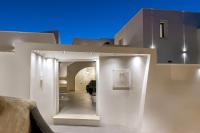 a white house with a sign on the wall at La Madeleine Oia in Oia