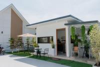 una casa blanca con una mesa y sillas en Space Water House พูลวิลล่าครอบครัว, en Ban Pong