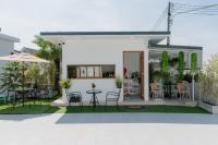 una casa con un patio con mesa y sillas en Space Water House พูลวิลล่าครอบครัว, en Ban Pong