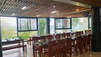 een eetkamer met tafels en stoelen en ramen bij Hidden An by An Bình Village in Yên Bái