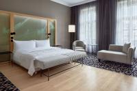 a hotel room with a bed and a chair at Le Méridien Vienna in Vienna