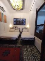 una habitación con dos camas y una ventana en Dar Lalla Wafae, en Fez