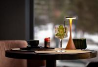 a table with a glass of wine and a candle at Hotel Simona Halep - Poiana Brasov in Poiana Brasov