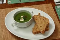 um prato com uma xícara de sopa e um pedaço de pão em The Retreat Hotel em Strathpeffer