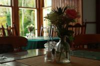 um vaso de vidro com rosas sobre uma mesa em The Retreat Hotel em Strathpeffer
