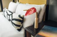 a table with a book and a red flower on a bed at Hotel Renew in Honolulu
