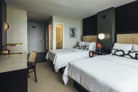 a hotel room with two beds and a desk at Hotel Renew in Honolulu