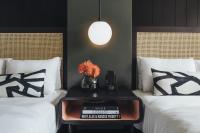 a room with two beds and a table with books at Hotel Renew in Honolulu