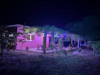 a house with a picnic table under a pergola at night at Bij Club in Bubaque