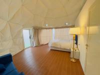 ein Schlafzimmer mit einem Bett und einer Lampe auf einem Holzboden in der Unterkunft Desert Night Camping in Dubai
