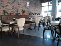 een eetkamer met tafels en stoelen en een bakstenen muur bij Aldino Residence in Ankara