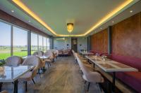 un ristorante con tavoli, sedie e finestre di Sukoon by The Ganges with Private Ganga Ghat a Haridwār