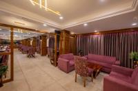 Un restaurante con sillas y mesas y cortinas moradas. en KC Vilaas Kufri, en Kūfrī