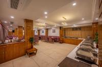 un restaurante con barra con mesas y sillas en KC Vilaas Kufri, en Kūfrī