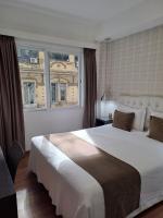 a bedroom with a large white bed and a window at Hotel Alvear in Montevideo