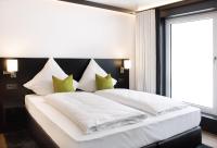 a bedroom with a large white bed with green pillows at WEN Hotel by WMM Hotels in Weiden