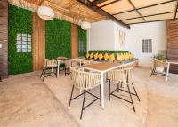 a patio with tables and chairs and a green wall at Cache Hotel Boutique - Adults Only in Playa del Carmen