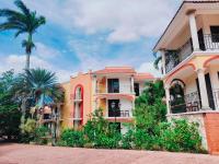 a yellow building with palm trees in front of it at Ecotel Quinta Regia in Valladolid