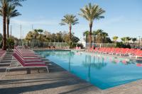 ein Swimmingpool mit Liegestühlen und Palmen in der Unterkunft Scarlet Pearl Casino Resort in Biloxi