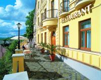 un edificio amarillo con un cartel en el costado en Wellness Hotel Jean De Carro, en Karlovy Vary