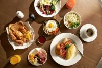 a wooden table with plates of food on it at voco Seoul Myeongdong by IHG in Seoul